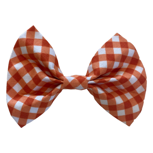 orange gingham plaid bow tie for dogs. two white velcro strips attach to collar.